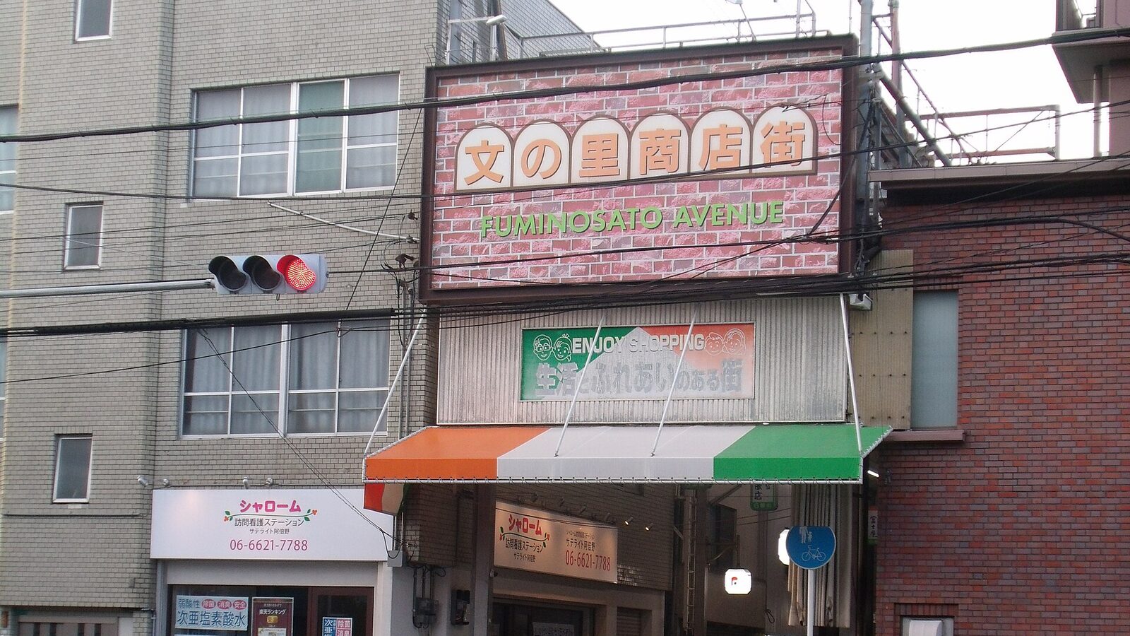 大阪市阿倍野区の文の里商店街の入口にかかる「文の里商店街 FUMINOSATO AVENUE」のアーチ看板と、その下の交差点