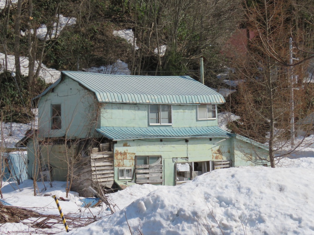 屋根と外壁が傷み倒壊が進んだ空き家　放置により建物の劣化が進行した状態の例