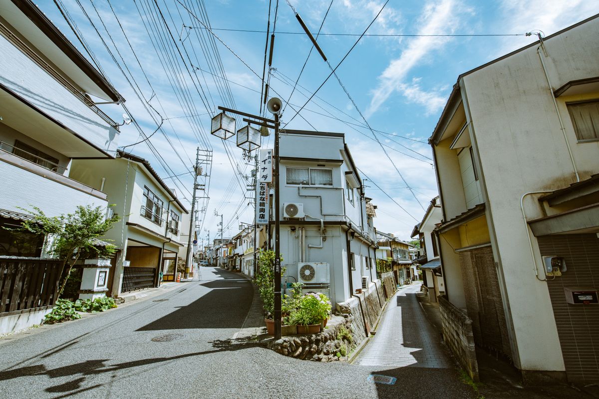 住宅が密集した街並みの中で細い道が二手に分かれている様子。前面道路が私道（公衆用道路）になっている典型的な区画