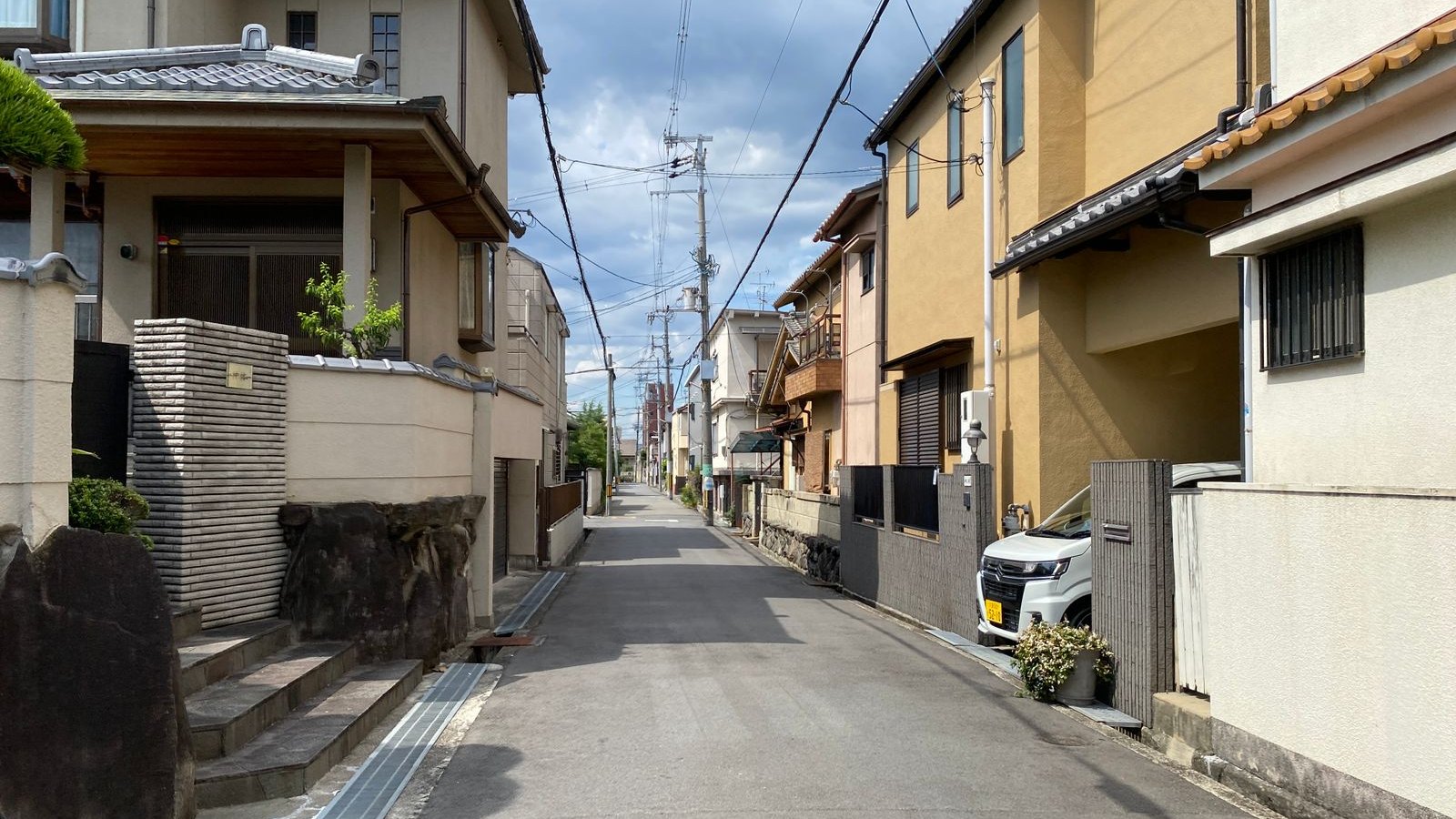 幅の狭い道路に古い木造住宅が建ち並ぶ日本の住宅街。大阪市の狭あい道路沿道の老朽住宅と解体補助金の対象エリア