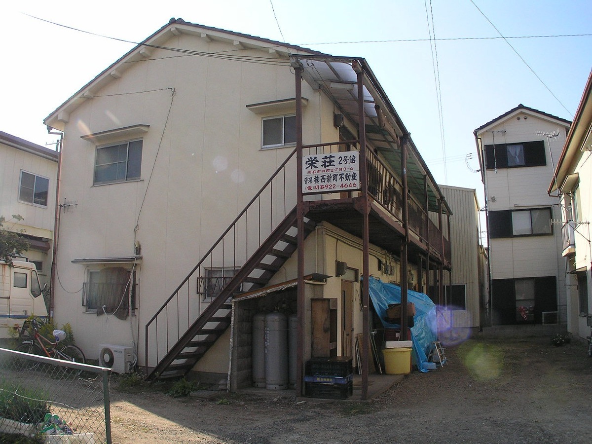 木造2階建ての文化住宅。外階段と2階の共用廊下、各戸の玄関が並ぶ昭和期の賃貸住宅
