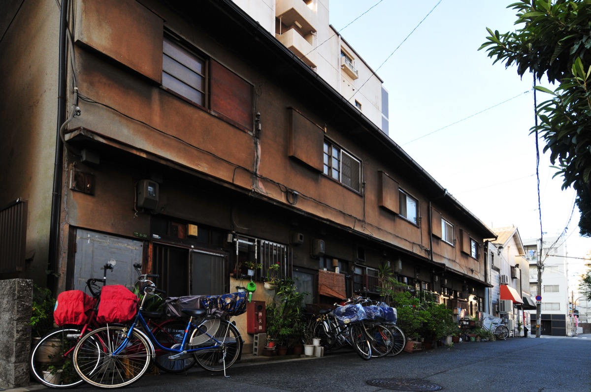 大阪市内の長屋。木造2階建てが横に連なり、各戸の玄関が直接道路に面して並んでいる