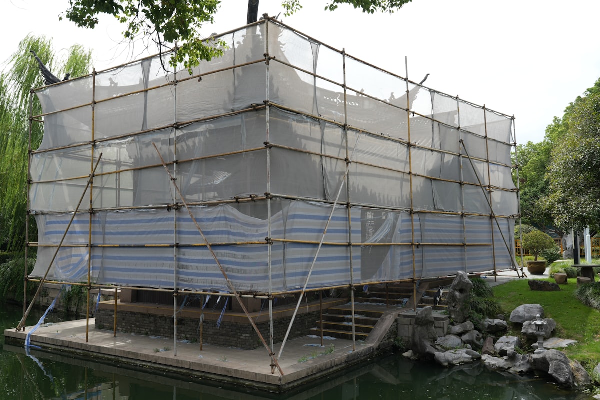 足場を組んで外壁・屋根の大規模修繕を行う賃貸アパート。複数の工事が同時期に重なると費用が一気に膨らむ