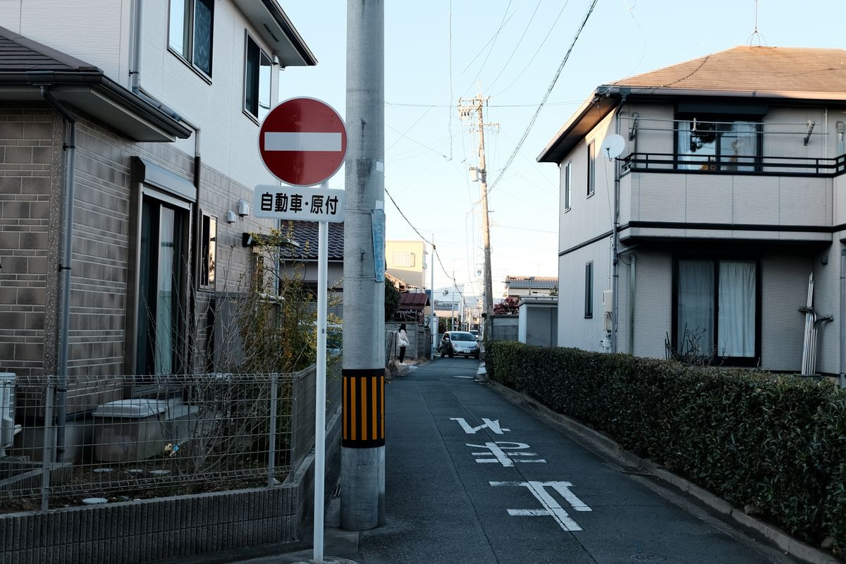 住宅街を通る道路。都市計画道路の予定地にかかった不動産の売却を検討するイメージ