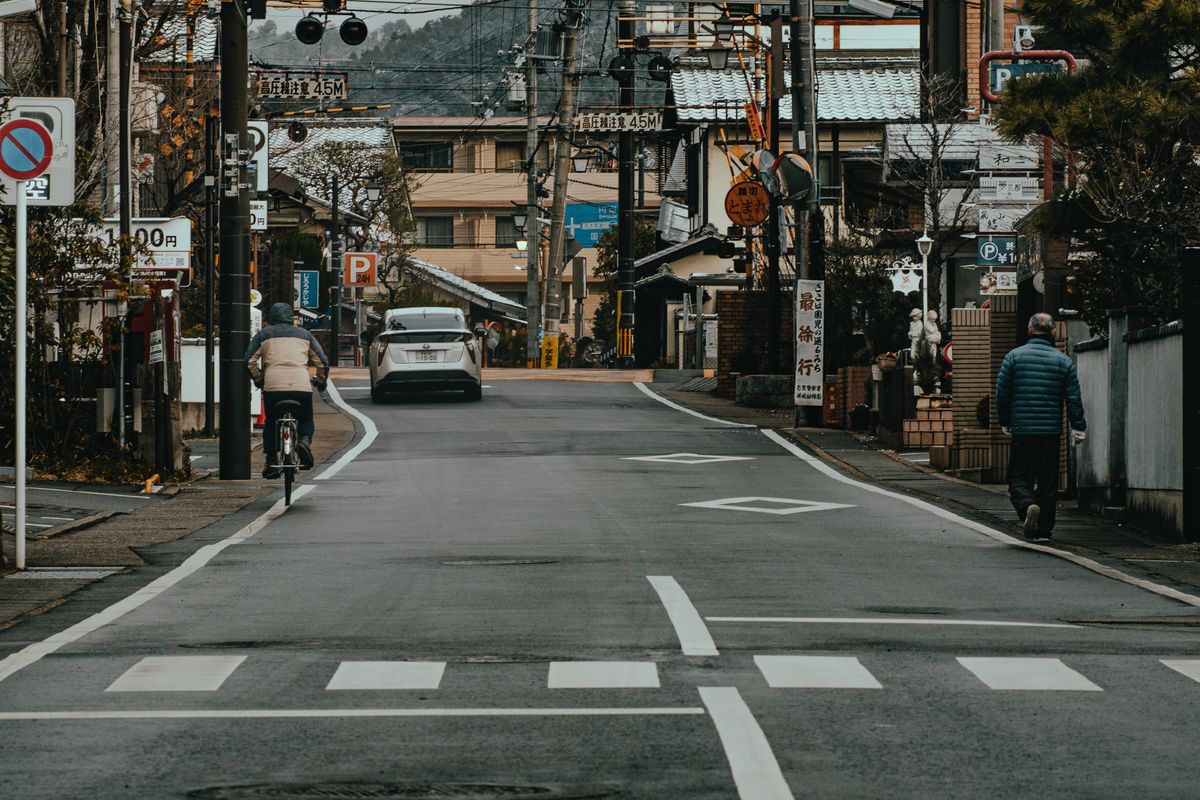 市街地を通る道路と沿道の建物。都市計画道路の拡幅予定にかかるエリアのイメージ